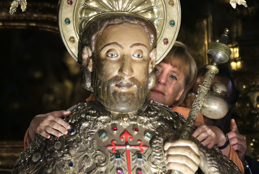 SPAIN, Santiago de Compostela : German Chancellor Angela Merkel embraces the statue of Saint James during a visit with Spanish Prime Minister Mariano Rajoy at the cathedral of Santiago de Compostela &#8211; fr