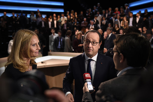 French President Francois Hollande (C) speaks to journalists after taking part in a French channel TF1 broadcast show
