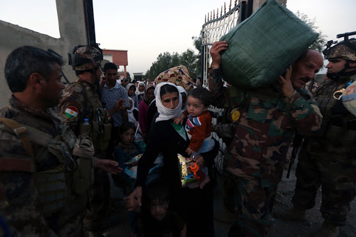 Kurdish Peshmerga forces help people from Iraq&rsquo;s Yazidi minority as they arrive at a medical center in the town of Altun Kupri &#8211; AFP &#8211; fr