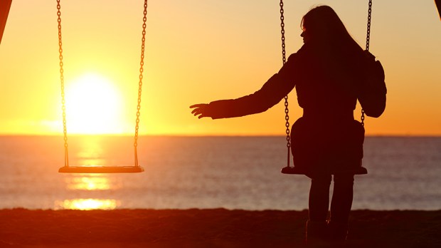 Single or divorced woman alone missing a boyfriend while swinging on the beach at sunset © Antonio Guillem / Shutterstock