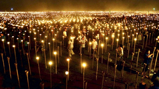 Volunteers light candles during the « Light of Peace in the Phili