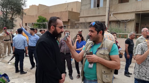 UN JOURNALISTE DE LA RADIO AL-SALAM ENREGISTRE UNE INTERVIEW À QARAQOSH (IRAK).