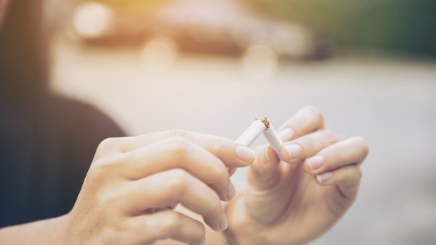 FEMME QUI CASSE EN DEUX UNE CIGARETTE