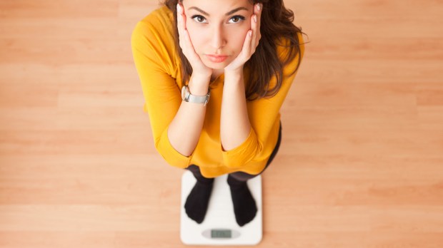 FEMME SE PESANT SUR UNE BALANCE