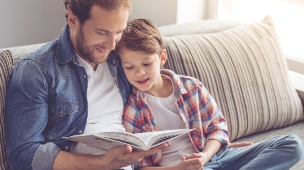 PERE ET SON FILS LISANT UN LIVRE