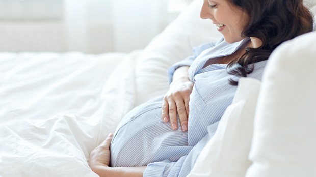 PREGNANT WOMAN LYING IN BED