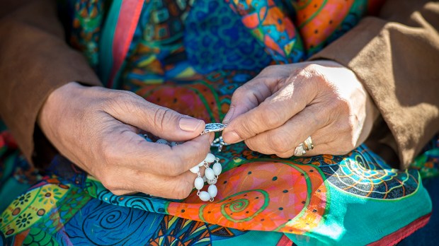 WOMAN PRAYING ROSARY