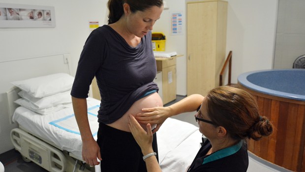 MIDWIFE CHECKS PREGNANT WOMAN