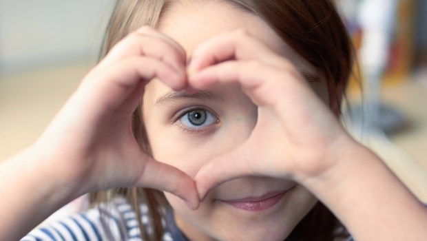 enfant faisant un coeur avec ses mains