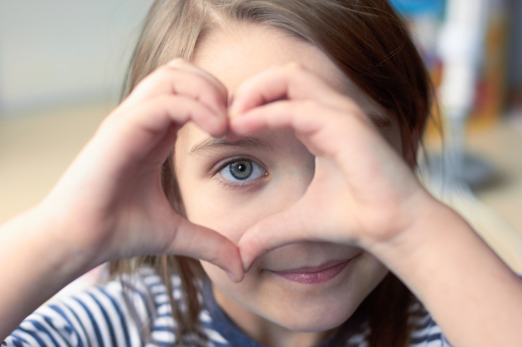 enfant faisant un coeur avec ses mains