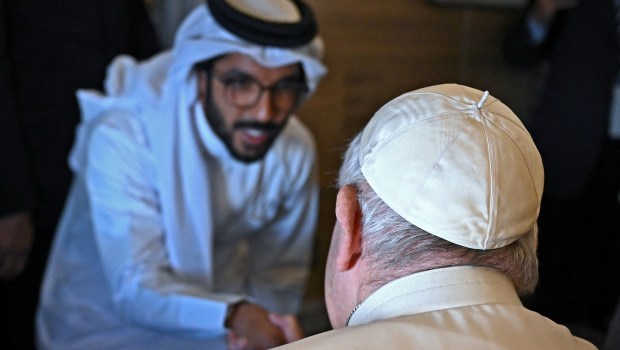 Pope-Francis-shakes-hands-with-a-journalist-from-his-seat-aboard-the-plane-from-Rome-to-Manama-AFP