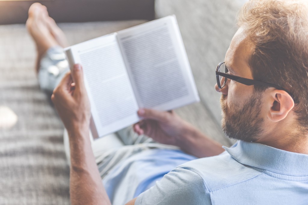 Man reading book at home