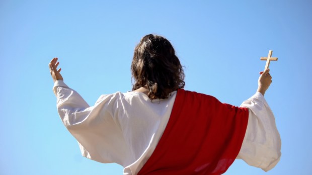 Saint prophet holding cross praying to God preaching Christianity back view