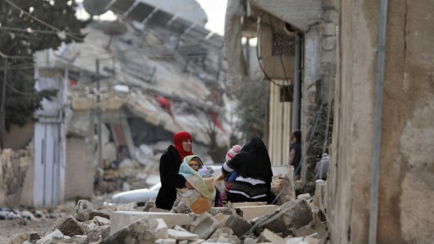 Syrian women and children sit wrapped in blankets outside collapsed buildings on February 7, 2023, in the town of Jandairis, in the rebel-held part of Aleppo province, as search and rescue operations continue following a deadly earthquake. - The death toll from the massive earthquake that struck Turkey and Syria rose above 8,300, official data showed, with rescue workers still searching for trapped survivors. (Photo by Bakr ALKASEM / AFP) - EN_01553763_1096.jpg