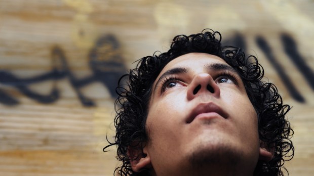 Portrait of young hispanic teen boy against grunge background