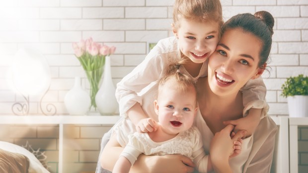 mother in bright room with baby and toddler