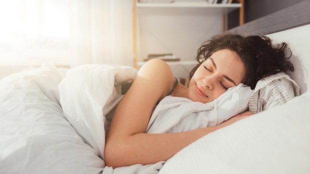 Sleepy female keeping eyes closed while dreaming