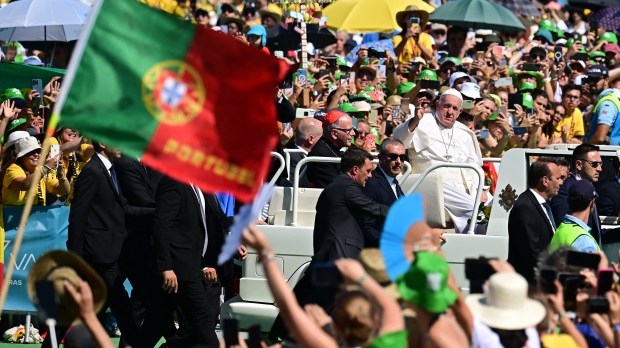 Pope Francis waves from the popemobile as he arrives for a meeting with volunteers of the World Young Day