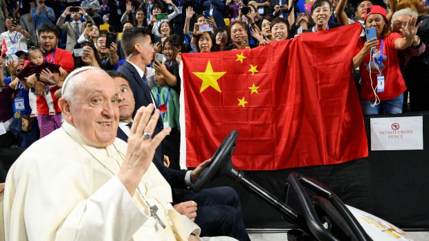 Pope Francis being driven past a Chinese flag during his arrival for Holy Mass at the Steppe Arena in Ulaanbaatar