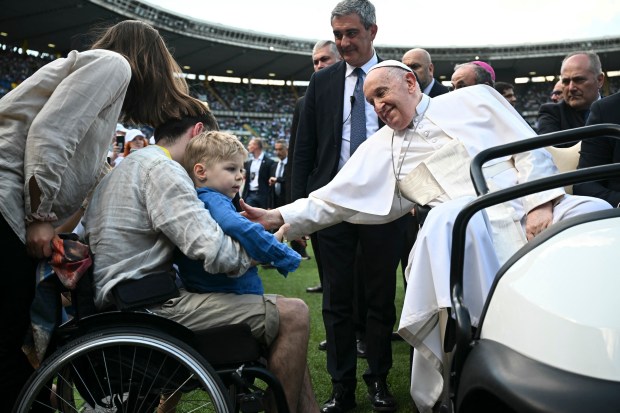 Pope Francis greets people as he arrives to lead a mass at the Bentegodi stadium as part of a visit in Verona, on May 18, 2024